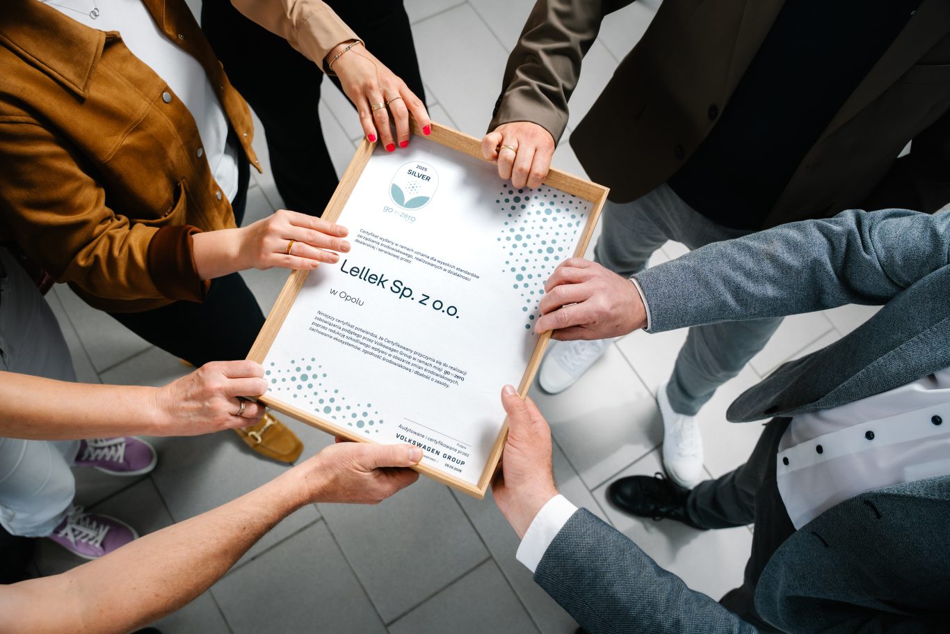 grupa ludzi trzyma certyfikat gotozero widok z góry