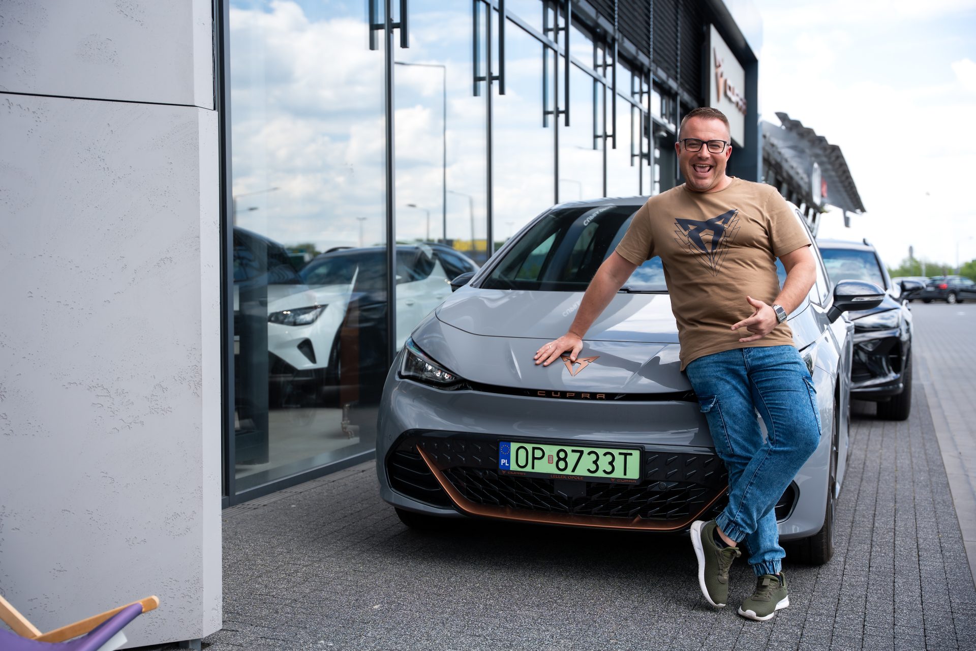 mężczyzna opiera się o cuprę born przed salonem cupra lellek opole